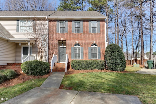 view of front facade featuring brick siding and a front yard