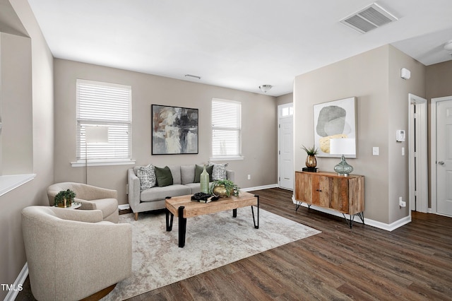 living area featuring dark wood finished floors, baseboards, and visible vents