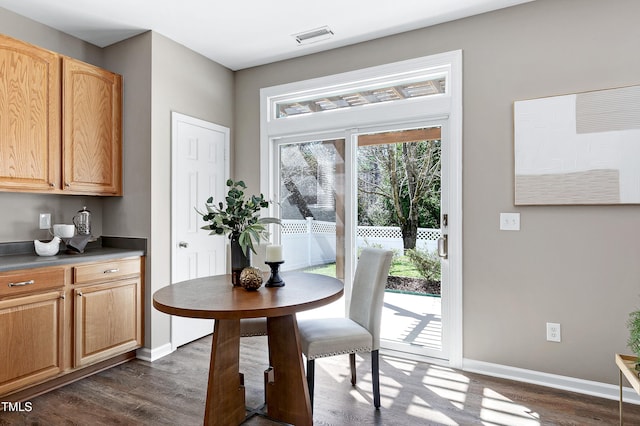 dining area with visible vents, baseboards, and dark wood-style flooring