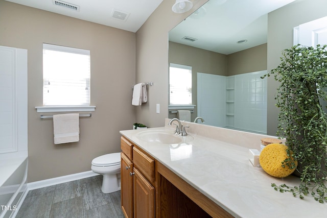 bathroom featuring visible vents, a healthy amount of sunlight, vanity, and baseboards