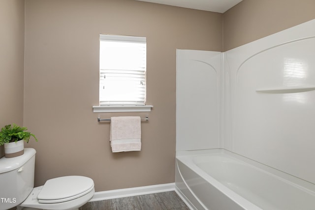 bathroom featuring toilet, wood finished floors, and baseboards