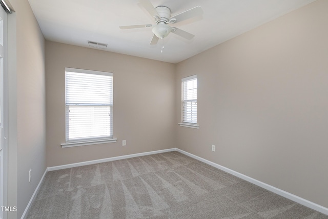 spare room featuring carpet, baseboards, visible vents, and ceiling fan