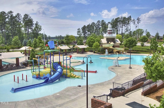 pool featuring fence, a water slide, and a water play area