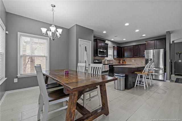 dining space with a chandelier, light tile patterned floors, recessed lighting, and baseboards