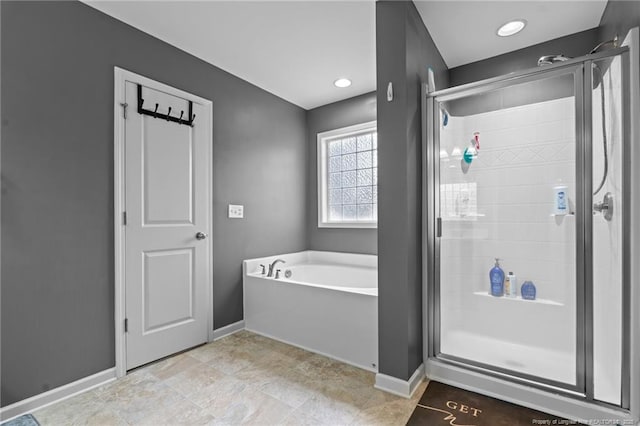 bathroom with a shower stall, a bath, and baseboards