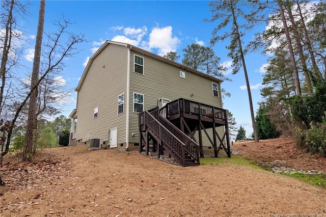 back of house with crawl space, a deck, and stairs