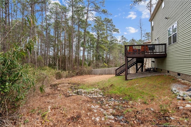 view of yard with a deck, stairway, and fence