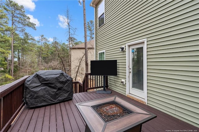 deck featuring a fire pit and a grill