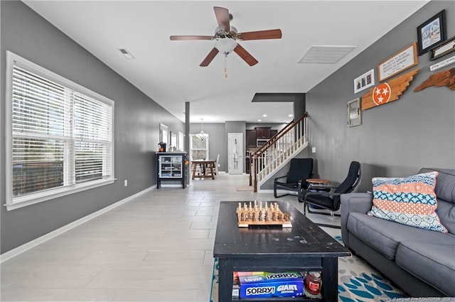 living area featuring visible vents, ceiling fan, stairs, and baseboards