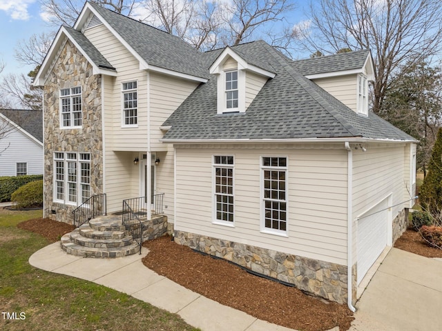 traditional home featuring stone siding and roof with shingles