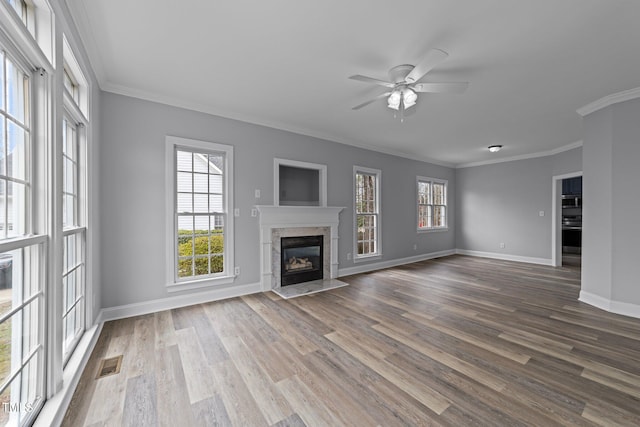 unfurnished living room with dark wood finished floors, visible vents, ornamental molding, and a premium fireplace