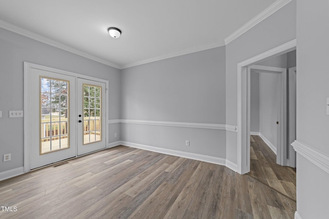 empty room featuring visible vents, wood finished floors, french doors, crown molding, and baseboards