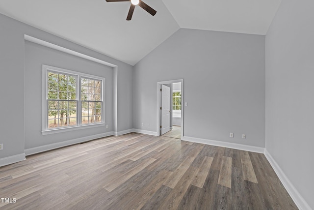 spare room with high vaulted ceiling, wood finished floors, baseboards, and ceiling fan