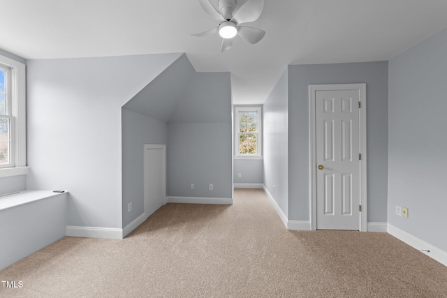 additional living space featuring vaulted ceiling, carpet flooring, a ceiling fan, and baseboards