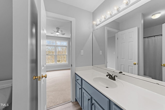 bathroom with toilet, vanity, and baseboards