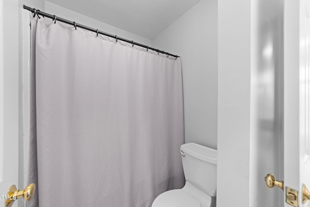 bathroom with a shower with shower curtain and toilet