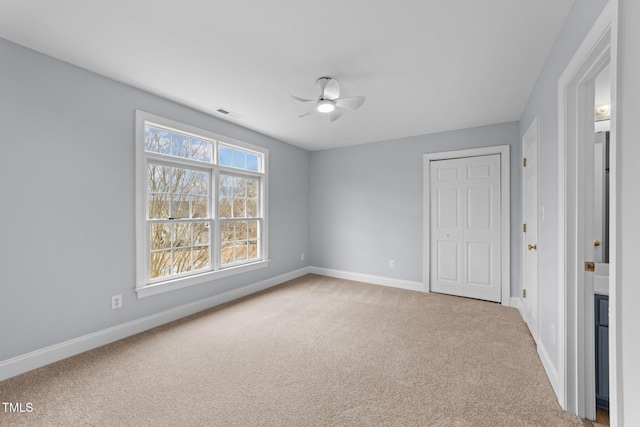 unfurnished bedroom with visible vents, ceiling fan, baseboards, and carpet