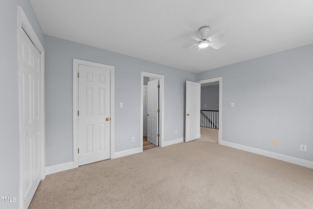 unfurnished bedroom with ensuite bath, baseboards, carpet floors, and ceiling fan