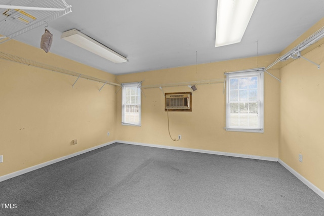 carpeted empty room featuring a wall mounted AC and baseboards