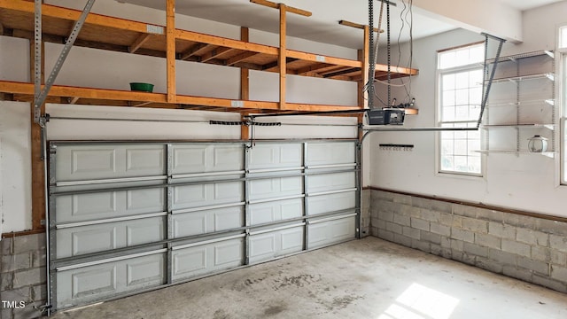 garage with concrete block wall and a garage door opener