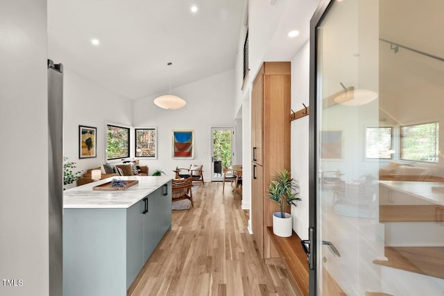 hall with recessed lighting, light wood-style floors, and high vaulted ceiling