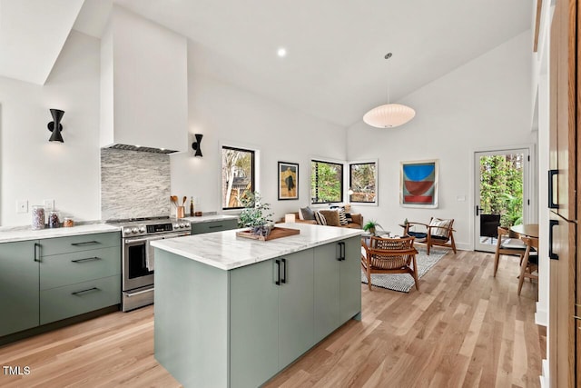 kitchen with light wood-type flooring, stainless steel range with electric stovetop, a kitchen island, and green cabinets