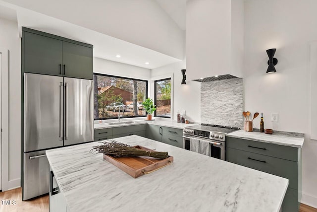 kitchen featuring light wood finished floors, gray cabinets, stainless steel appliances, and a sink