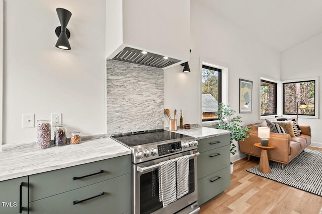 kitchen featuring gray cabinetry, light wood-style flooring, green cabinets, stainless steel electric range oven, and custom exhaust hood