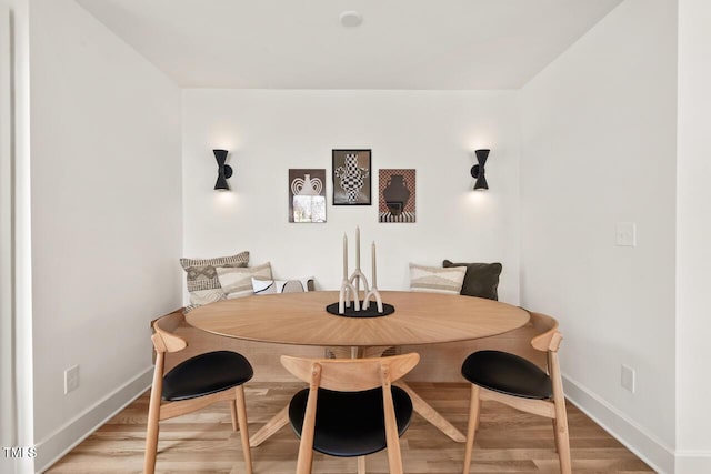 dining space with baseboards and light wood-style floors