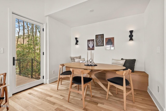 dining area with baseboards and light wood finished floors