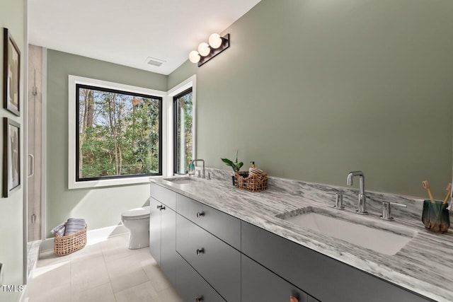 full bath featuring tile patterned flooring, double vanity, toilet, and a sink