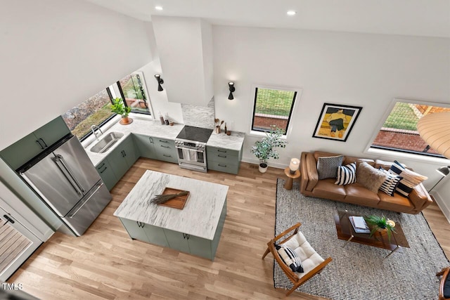 living area with recessed lighting, a high ceiling, and light wood finished floors