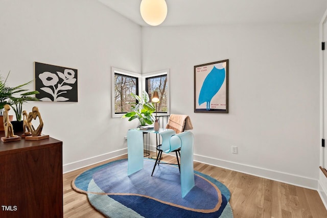 office area featuring baseboards, lofted ceiling, and wood finished floors