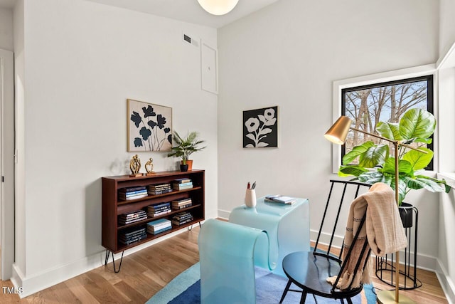 home office with baseboards, a high ceiling, and wood finished floors