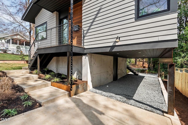 view of property exterior featuring stairs and fence