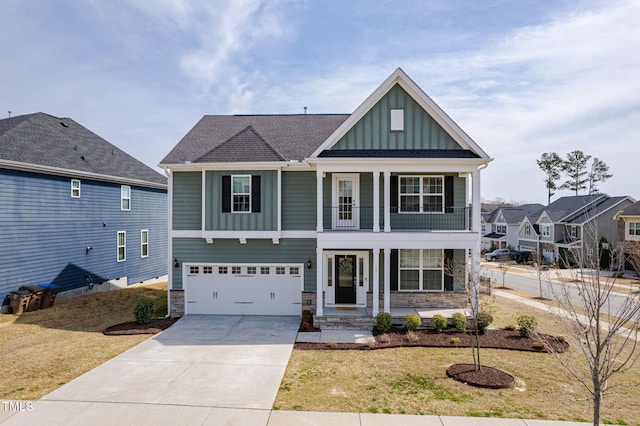 craftsman inspired home with board and batten siding, a garage, a balcony, stone siding, and driveway