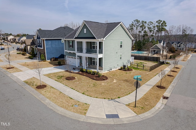 view of front of home featuring fence, a residential view, concrete driveway, covered porch, and a garage