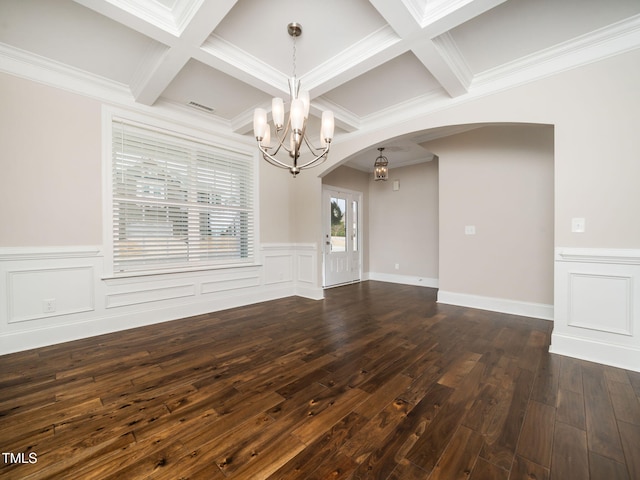 spare room featuring beam ceiling, a notable chandelier, dark wood-type flooring, coffered ceiling, and arched walkways