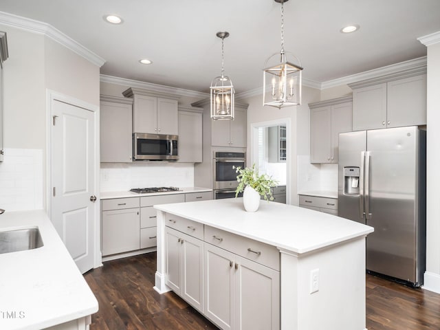 kitchen with a kitchen island, dark wood-type flooring, ornamental molding, gray cabinets, and appliances with stainless steel finishes