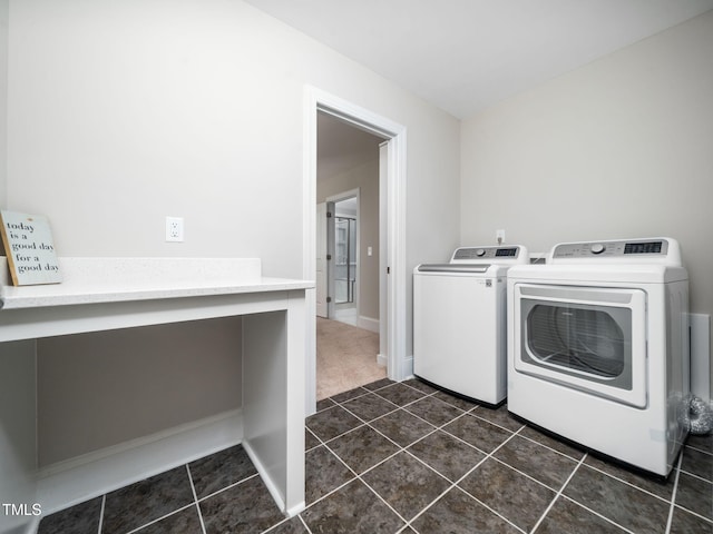 laundry area with dark tile patterned floors, separate washer and dryer, dark colored carpet, baseboards, and laundry area