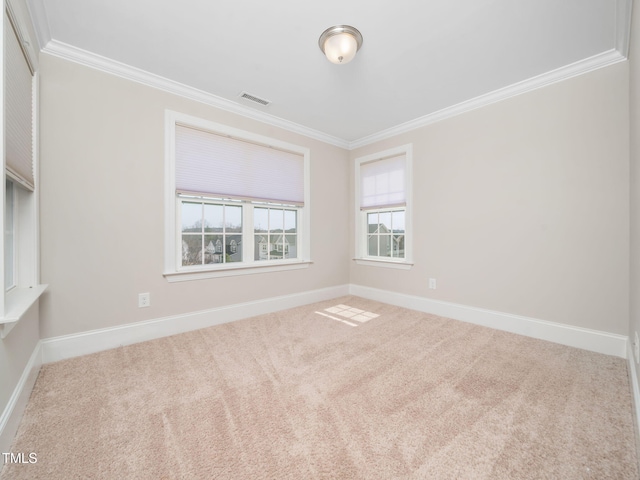 empty room with crown molding, carpet flooring, baseboards, and visible vents