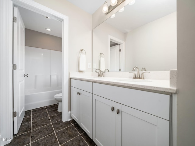 bathroom featuring tile patterned flooring, double vanity, toilet, and a sink