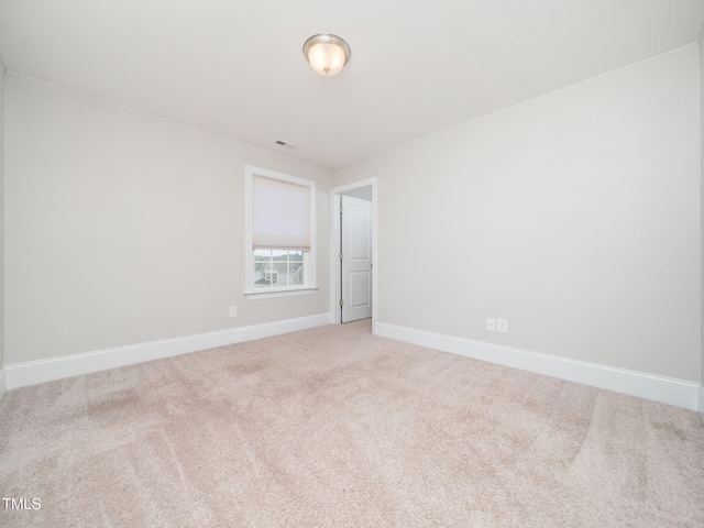 carpeted spare room featuring visible vents and baseboards