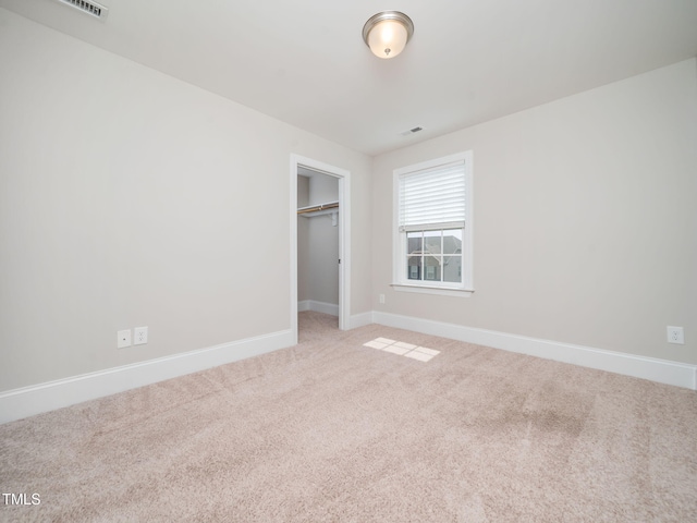 unfurnished bedroom featuring visible vents, baseboards, carpet, and a closet