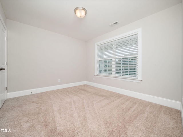 carpeted empty room featuring visible vents and baseboards