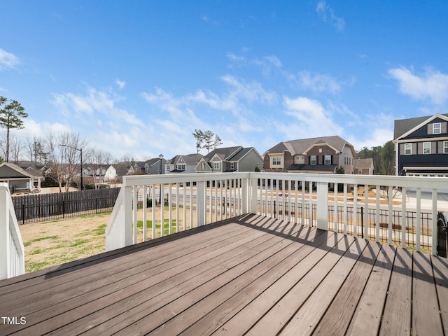 wooden deck with a fenced backyard, a residential view, and a lawn