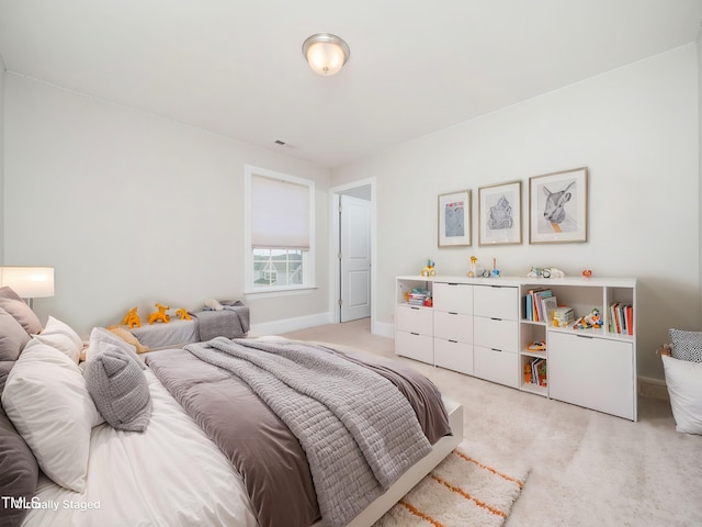 bedroom featuring baseboards, visible vents, and light carpet