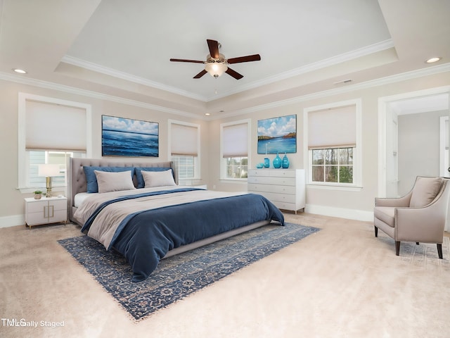 carpeted bedroom with a tray ceiling, visible vents, baseboards, and ornamental molding