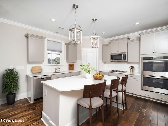 kitchen featuring visible vents, appliances with stainless steel finishes, a breakfast bar, and gray cabinetry