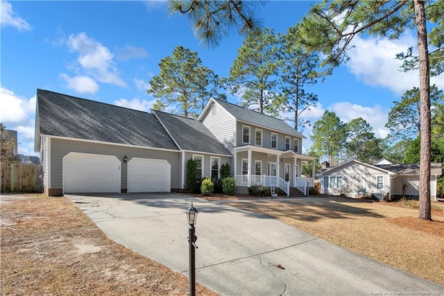 colonial home featuring driveway, a porch, fence, a shingled roof, and a garage